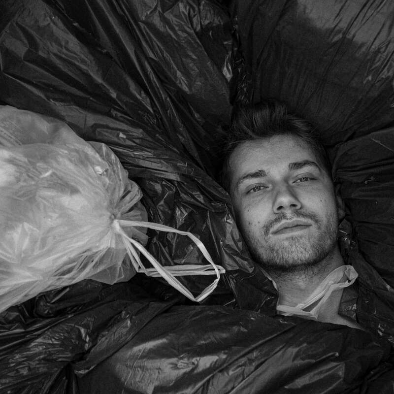 man covered in trash bags